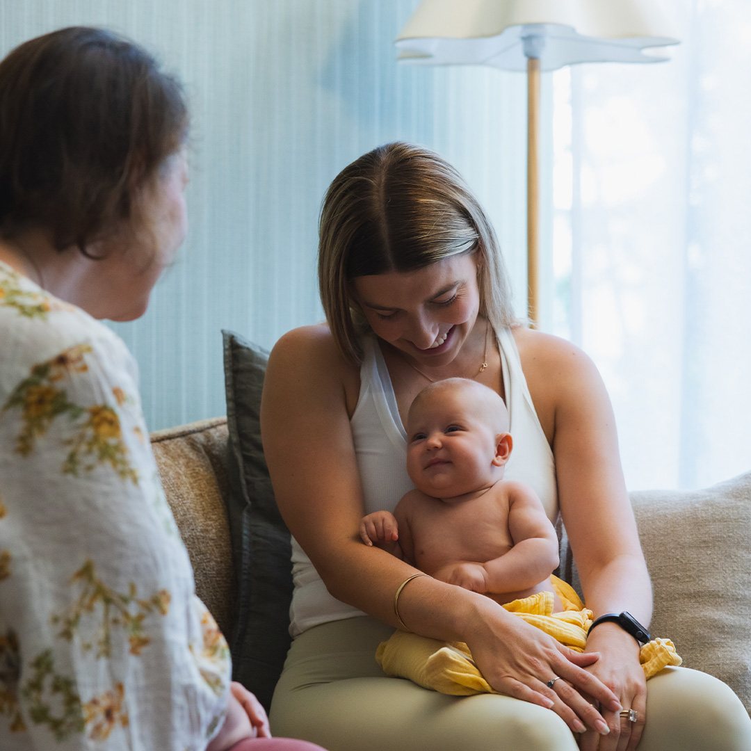 A mum holding her baby with an MBC midwife